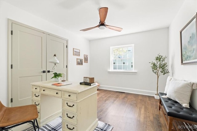 home office featuring baseboards, a ceiling fan, wood finished floors, and visible vents