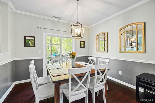 dining room with visible vents, wood finished floors, baseboards, a chandelier, and ornamental molding