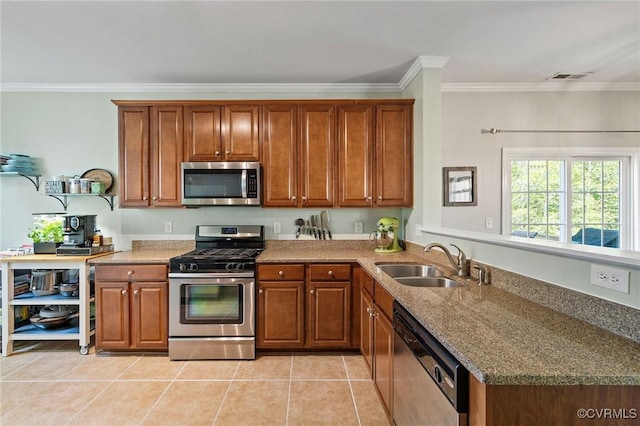 kitchen featuring visible vents, appliances with stainless steel finishes, brown cabinets, a sink, and light tile patterned floors