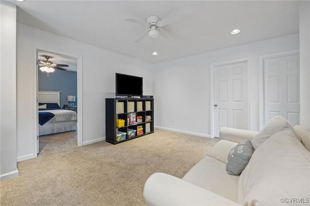 living area with baseboards, carpet, and ceiling fan