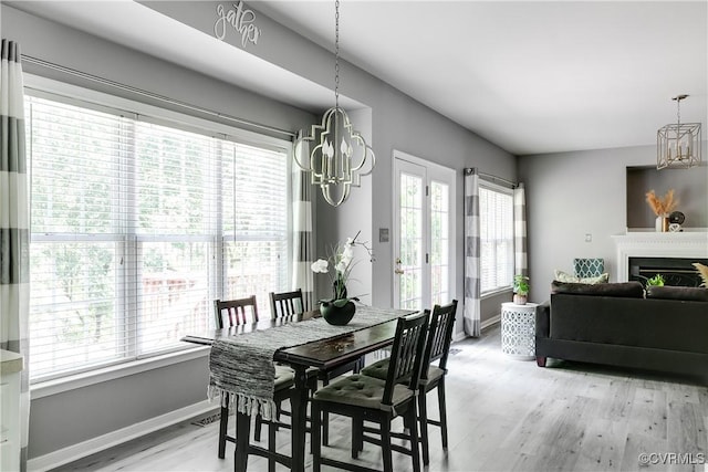 8134 Falling Leaf Ct, Mechanicsville, VA 23111 - dining room featuring a chandelier, light wood-style floors, and a fireplace