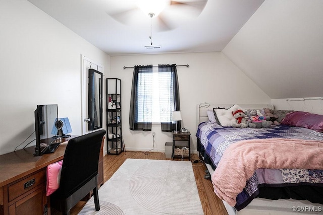 bedroom featuring visible vents, a ceiling fan, light wood-style flooring, and lofted ceiling