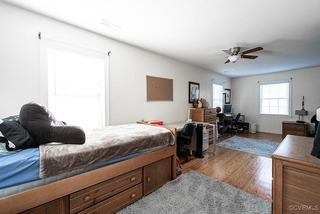 bedroom with visible vents, ceiling fan, and wood finished floors