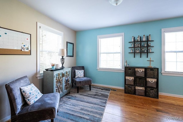 sitting room with baseboards and wood finished floors
