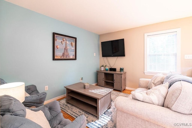 living area featuring baseboards and light wood-style flooring