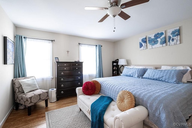 bedroom featuring baseboards, a ceiling fan, and wood finished floors