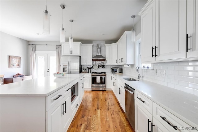 1207 N 21st St, Richmond, VA 23223 - kitchen featuring decorative light fixtures, tasteful backsplash, a sink, stainless steel appliances, and wall chimney exhaust hood