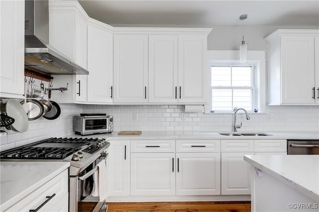 1207 N 21st St, Richmond, VA 23223 - kitchen featuring wall chimney range hood, tasteful backsplash, a sink, white cabinets, and stainless steel appliances