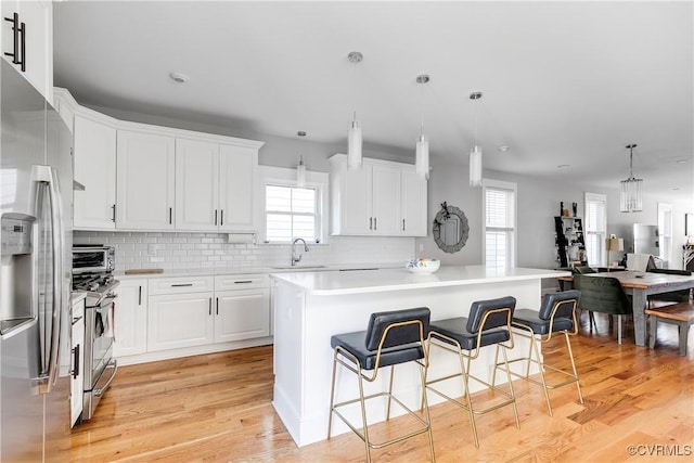 1207 N 21st St, Richmond, VA 23223 - kitchen with a healthy amount of sunlight, a kitchen bar, a center island, a sink, and stainless steel appliances