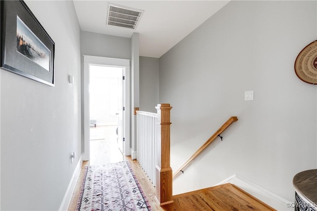 1207 N 21st St, Richmond, VA 23223 - corridor featuring visible vents, baseboards, wood finished floors, and an upstairs landing