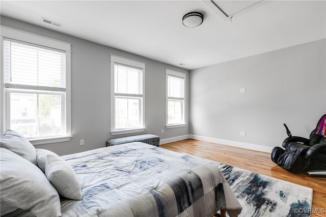 1207 N 21st St, Richmond, VA 23223 - bedroom with baseboards, attic access, wood finished floors, and visible vents