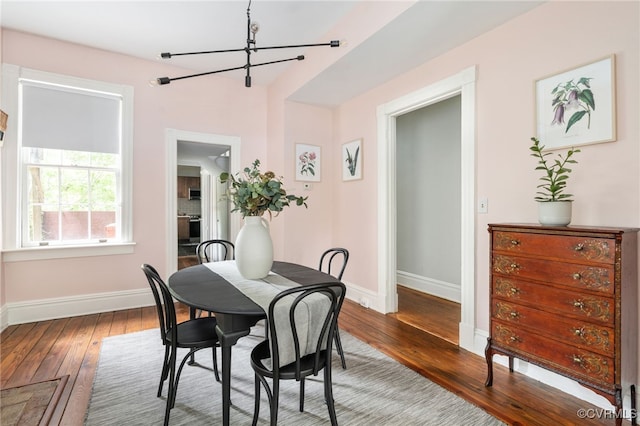 dining area featuring baseboards, a chandelier, and hardwood / wood-style floors