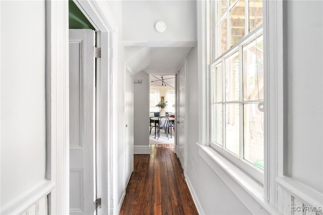 hallway featuring baseboards and dark wood finished floors