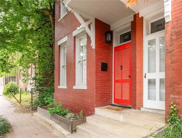 doorway to property with brick siding