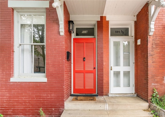 entrance to property featuring brick siding and a porch