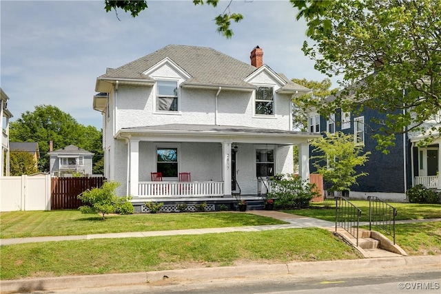 view of front of home with fence, stucco siding, a front yard, a chimney, and covered porch