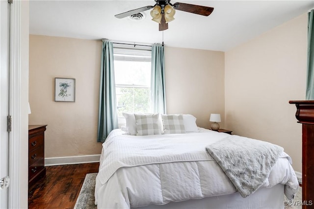 bedroom featuring a ceiling fan, baseboards, visible vents, and wood finished floors
