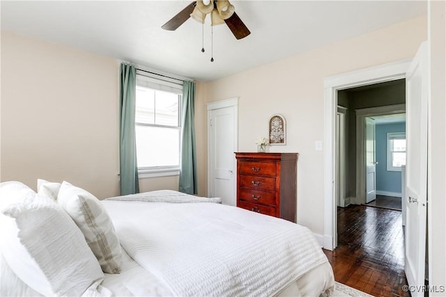 bedroom featuring baseboards, a ceiling fan, and dark wood-style floors