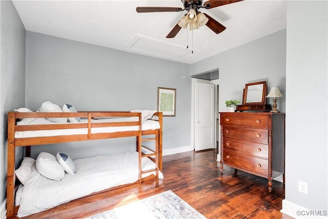 bedroom with baseboards, attic access, ceiling fan, and wood finished floors