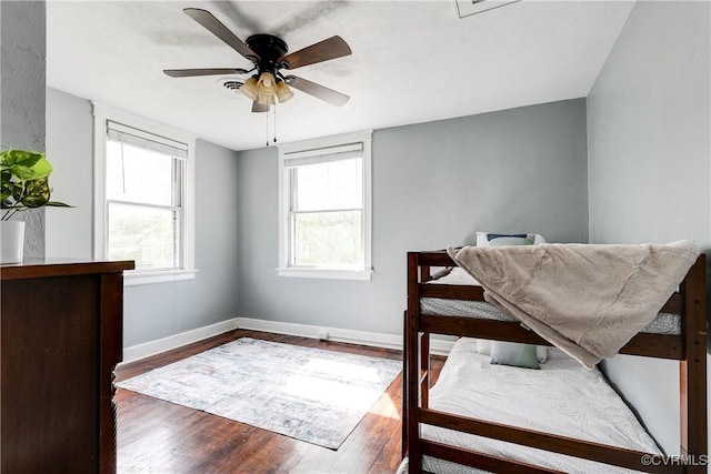 interior space with baseboards, ceiling fan, and wood finished floors
