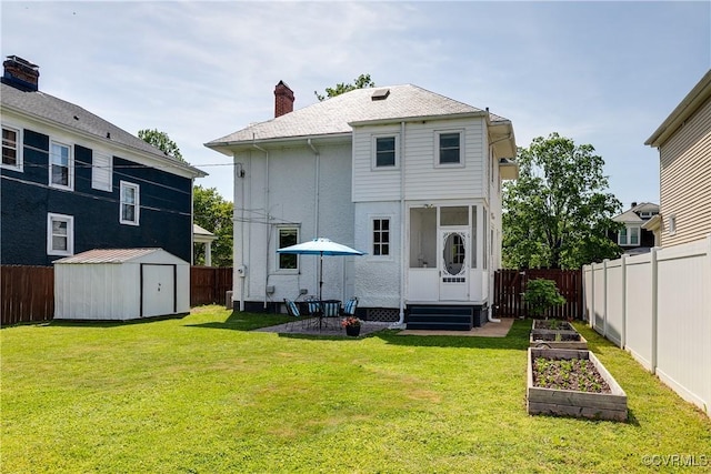 back of property with a fenced backyard, a yard, a vegetable garden, and a storage shed