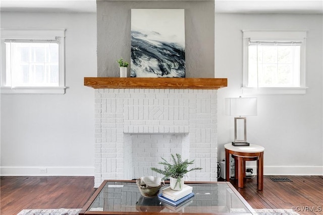 interior details featuring baseboards, wood finished floors, and a fireplace