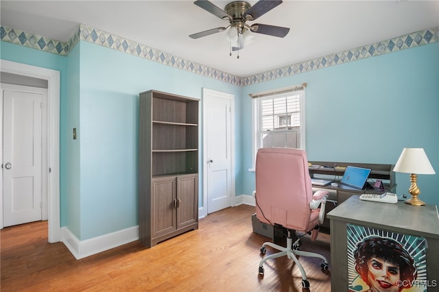 office featuring baseboards, ceiling fan, and light wood-type flooring