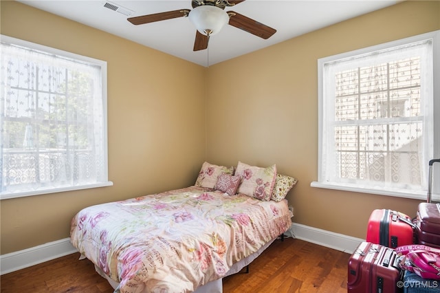 bedroom with visible vents, baseboards, ceiling fan, and wood finished floors