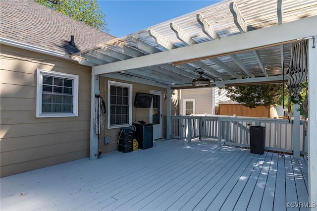 wooden deck featuring ceiling fan and a pergola