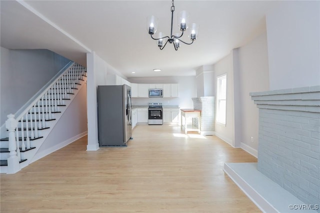 2014 Dinwiddie Ave, Richmond, VA 23224 - kitchen with stainless steel appliances, white cabinetry, a chandelier, and light wood-style floors