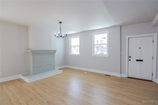 2014 Dinwiddie Ave, Richmond, VA 23224 - unfurnished living room featuring a chandelier, a fireplace, and light wood-style floors