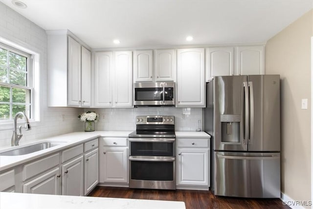 kitchen featuring white cabinetry, stainless steel appliances, tasteful backsplash, and a sink