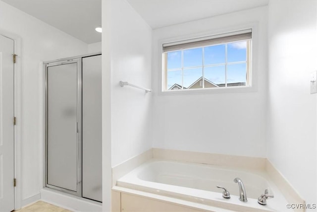 bathroom with a shower stall and a bath