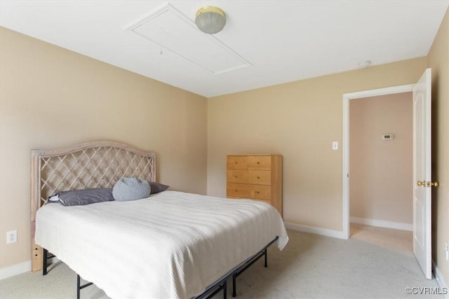 bedroom with attic access, baseboards, and carpet