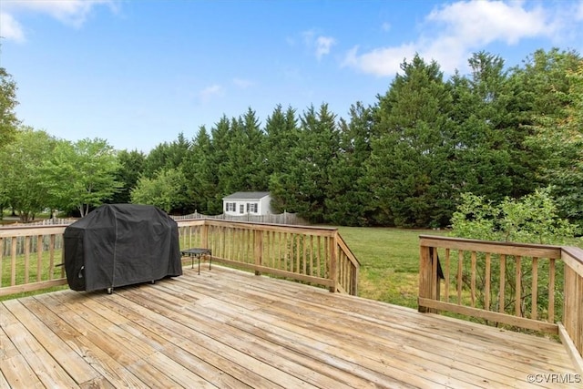 wooden deck with a yard, area for grilling, and a fenced backyard
