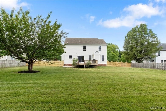 back of house with a fenced backyard, a deck, and a lawn