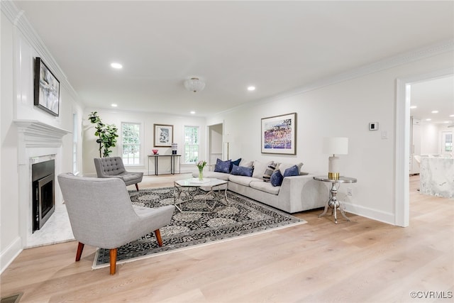 living area with crown molding, recessed lighting, and light wood finished floors