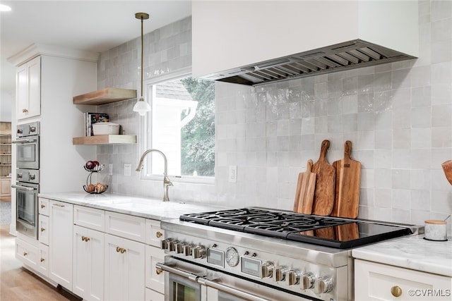 kitchen featuring open shelves, appliances with stainless steel finishes, backsplash, and wall chimney range hood