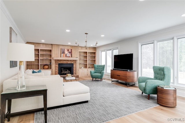 living area featuring recessed lighting, ornamental molding, wood finished floors, and a fireplace