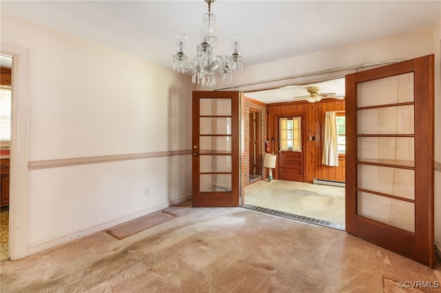 3006 Douglasdale Rd, Richmond, VA 23221 - carpeted spare room featuring wooden walls, a baseboard heating unit, french doors, and ceiling fan with notable chandelier