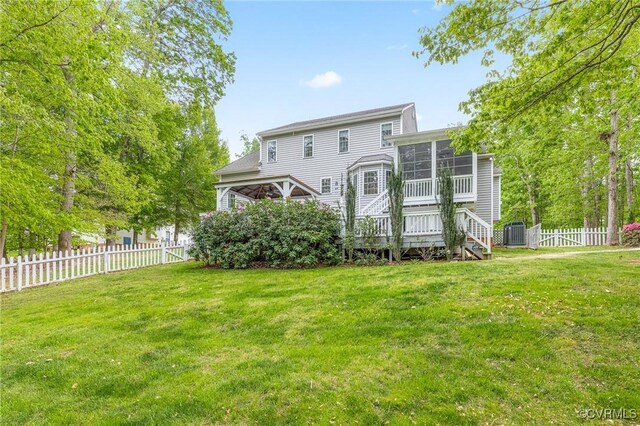 back of house with central AC unit, a sunroom, stairway, a fenced backyard, and a yard