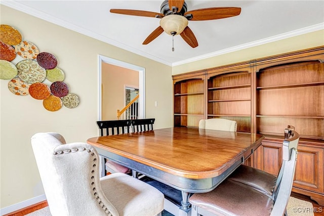 dining space with ceiling fan and ornamental molding