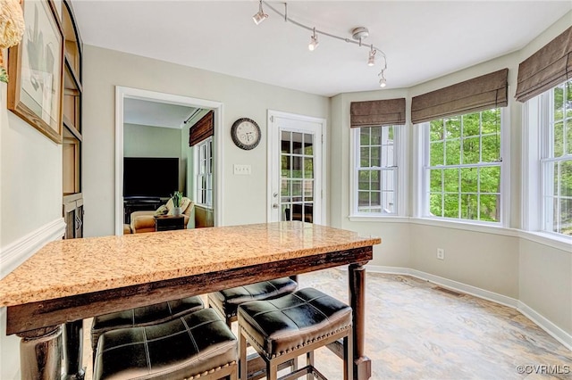 dining space with baseboards, visible vents, and stone finish floor