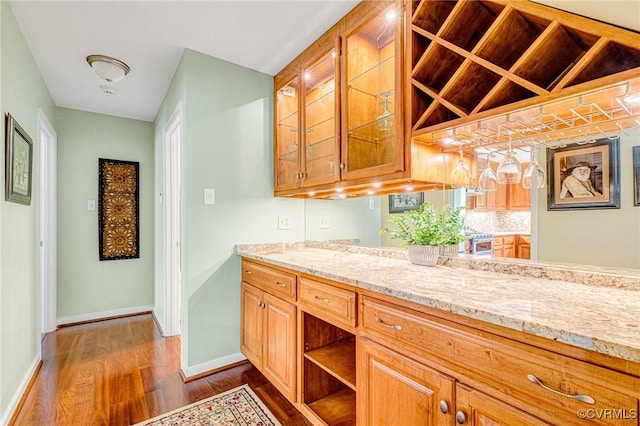 bar with baseboards, stainless steel gas range oven, dark wood-style flooring, and a dry bar