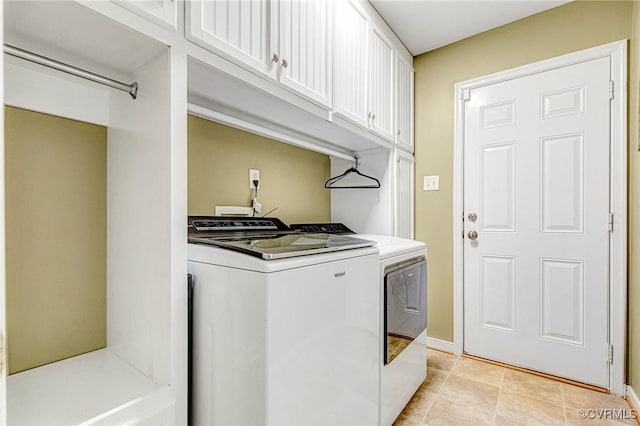 clothes washing area with baseboards, cabinet space, washing machine and dryer, and light tile patterned flooring