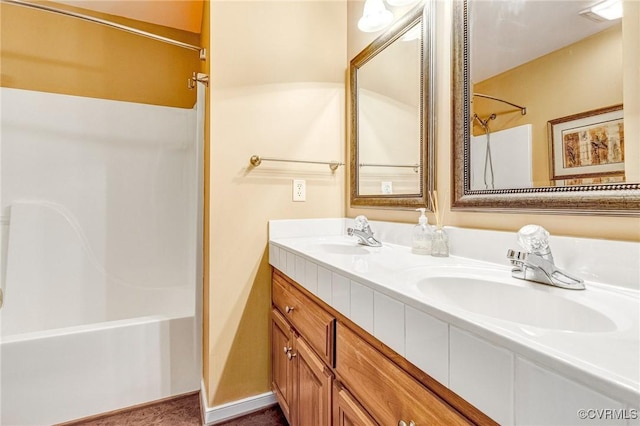 bathroom featuring double vanity, a sink, and  shower combination
