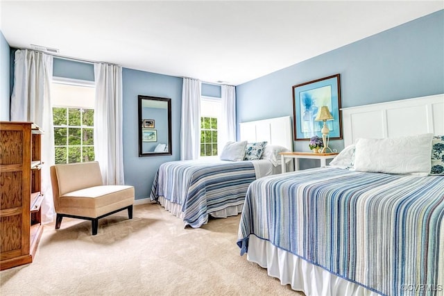 bedroom featuring light colored carpet, multiple windows, and visible vents
