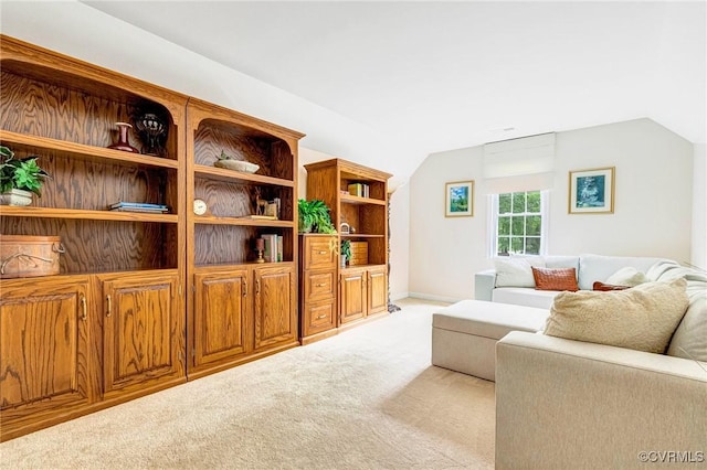 living area featuring vaulted ceiling and light carpet