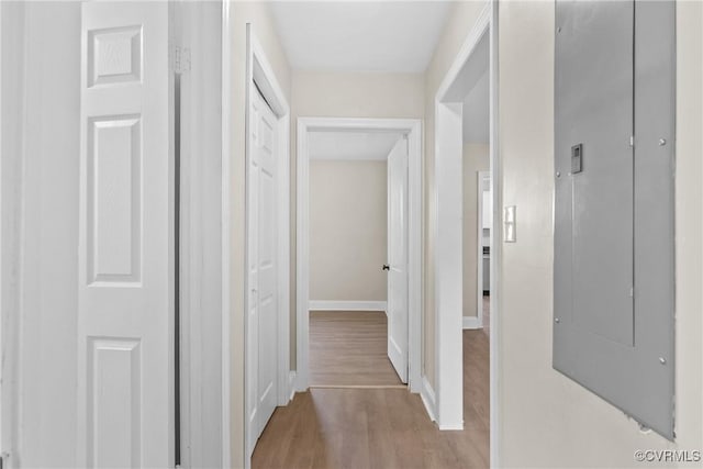 hallway featuring baseboards and wood finished floors