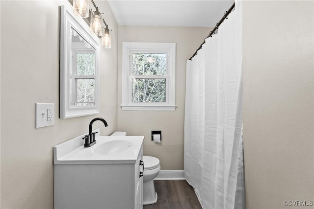full bathroom with vanity, toilet, a shower with shower curtain, baseboards, and wood finished floors